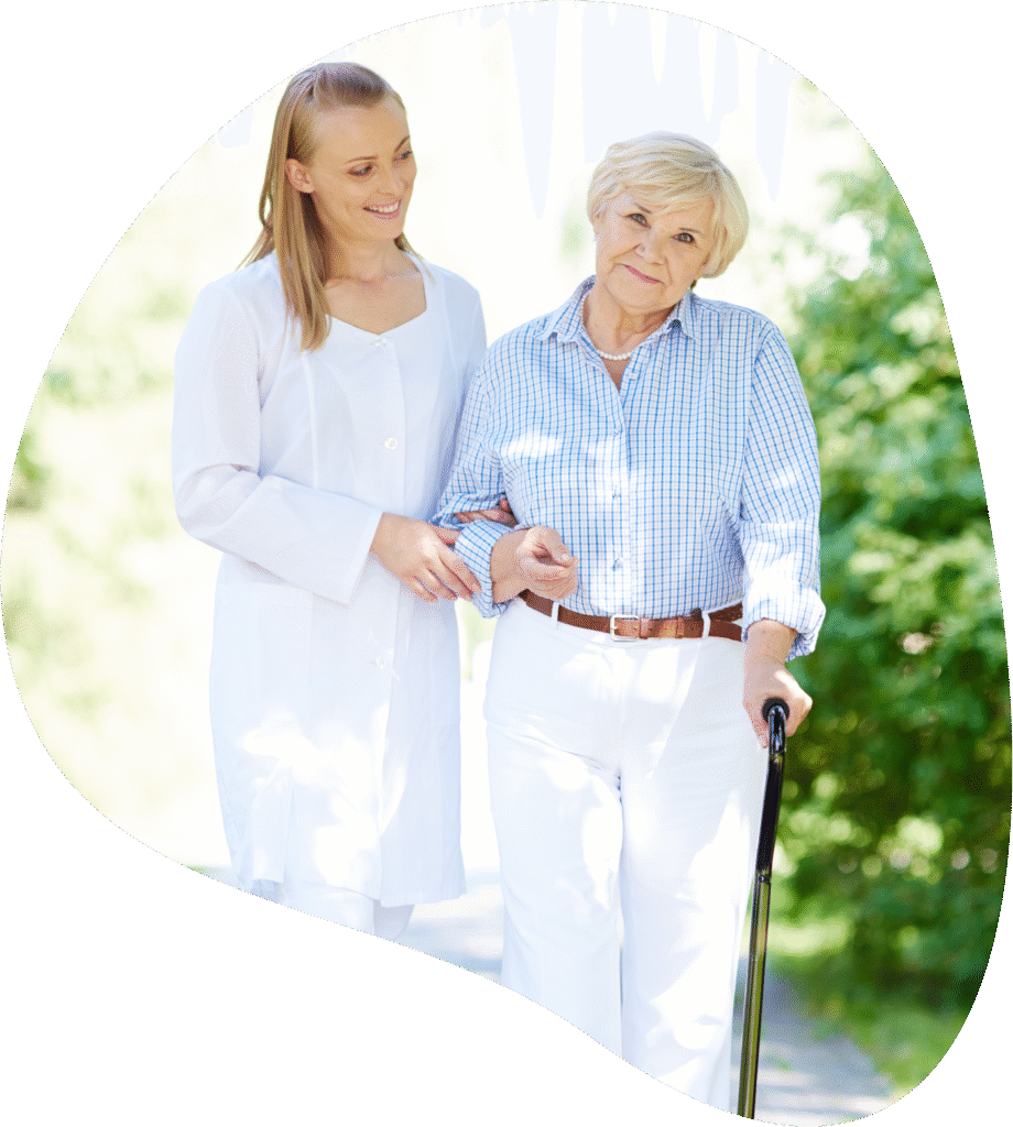 Professional caregiver assisting senior woman with walking cane outdoors in Denver home care setting.